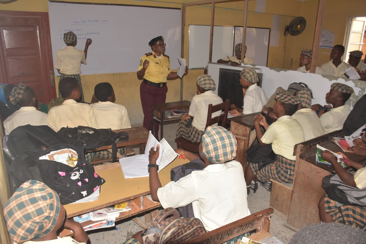 A LASTMA officer teaches the three types of traffic signs at a whiteboard
